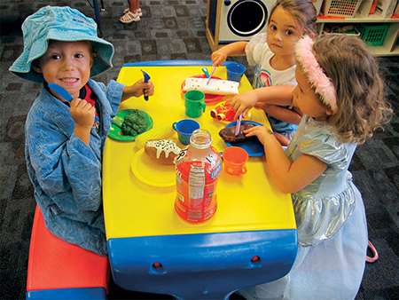 girls playing with food at table